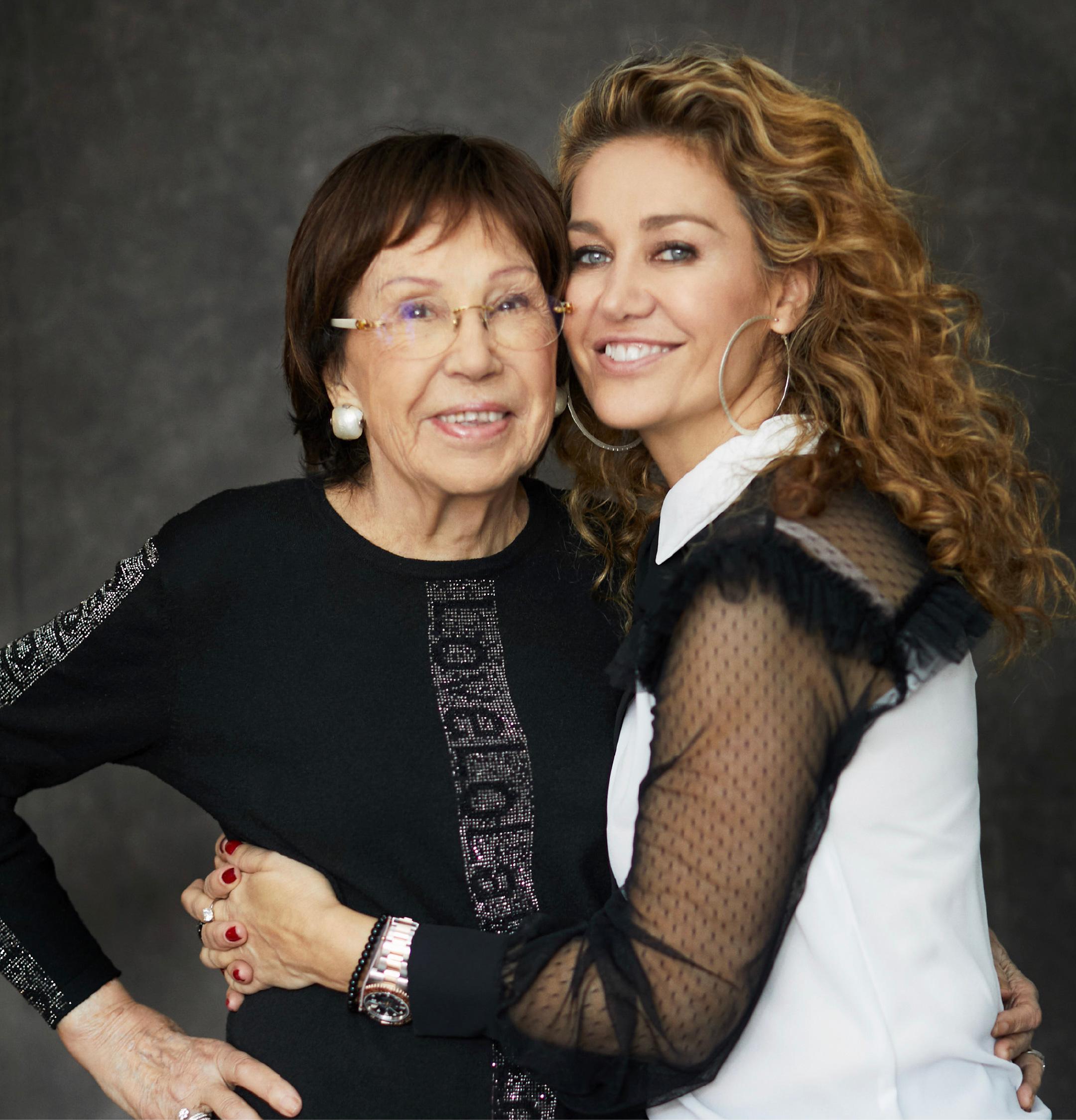 Retrato de Maite Casademunt abrazando a su madre Lola. Ambas sonríen a cámara.