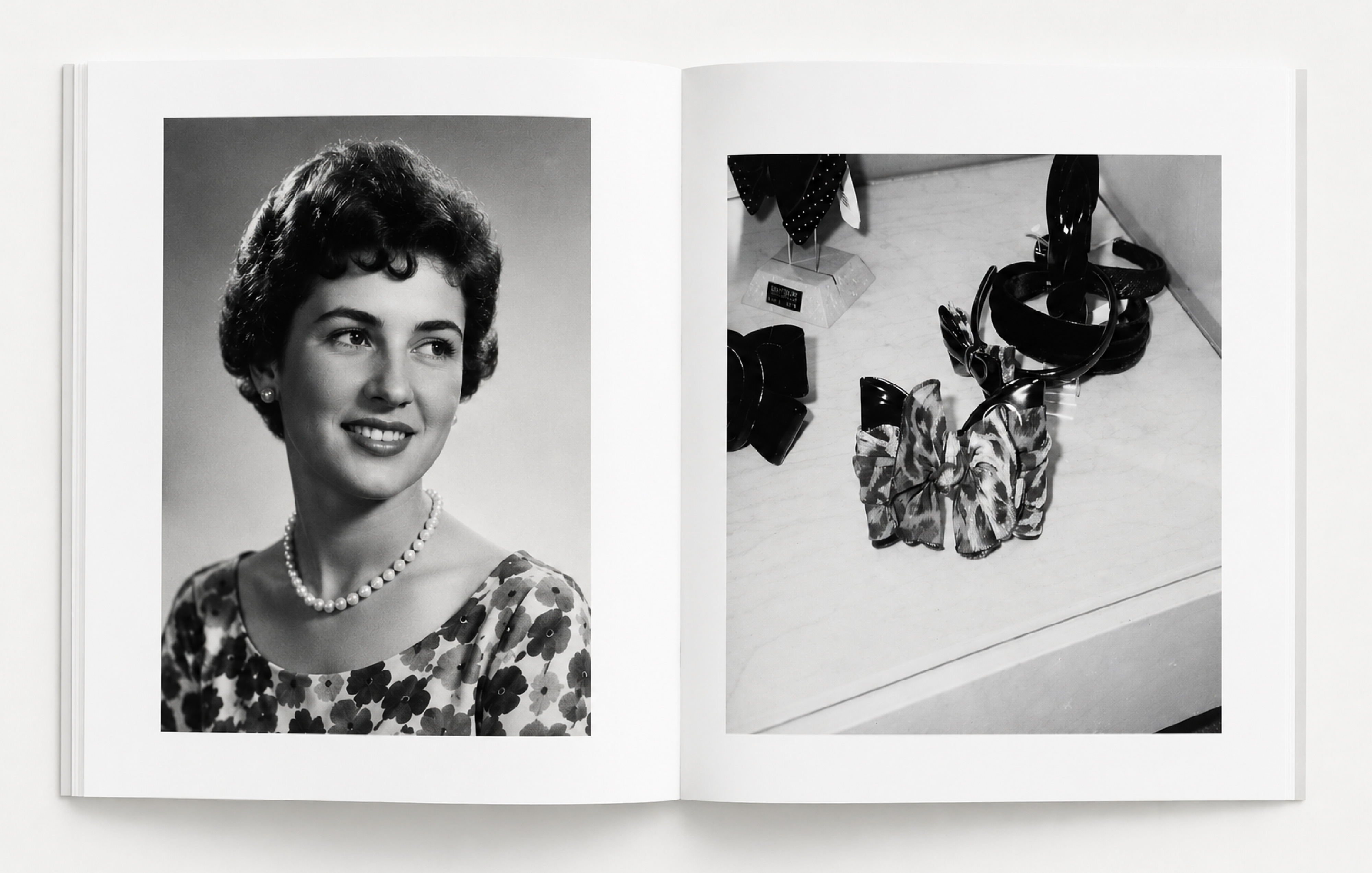 Un libro abierto. Cada página está ocupada por una foto en blanco y negro a gran tamaño, sin textos. La página de la izquierda muestra un retrato de estudio, en primer plano, de Lola Casademunt de joven, sonriendo y mirando hacia su izquierda. Luce un pendiente en forma de perla, un collar de perlas blancas y un vestido con un estampado de flores. La página derecha es un plano detalle de varios complementos, entre los que destaca, en primer plano, un gran lazo estampado.
